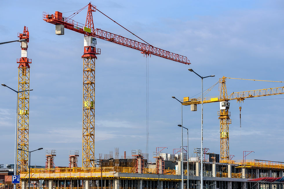 Construction site with multiple cranes and building frameworks under development, representing large-scale construction projects and sustainable building practices.